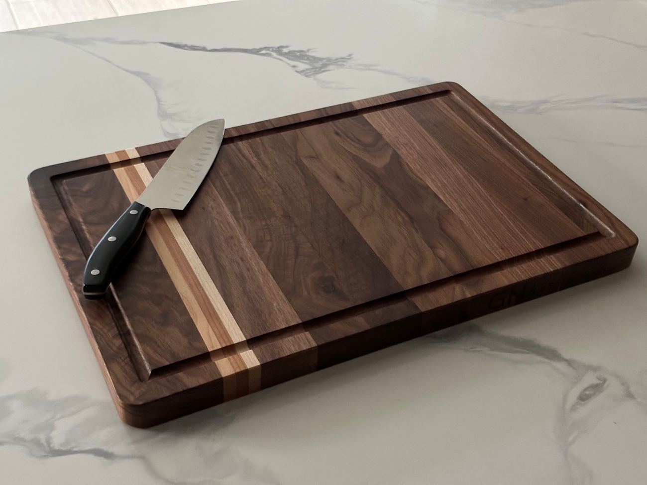 Brazilian black walnut cutting board with juice grooves and chef's knife